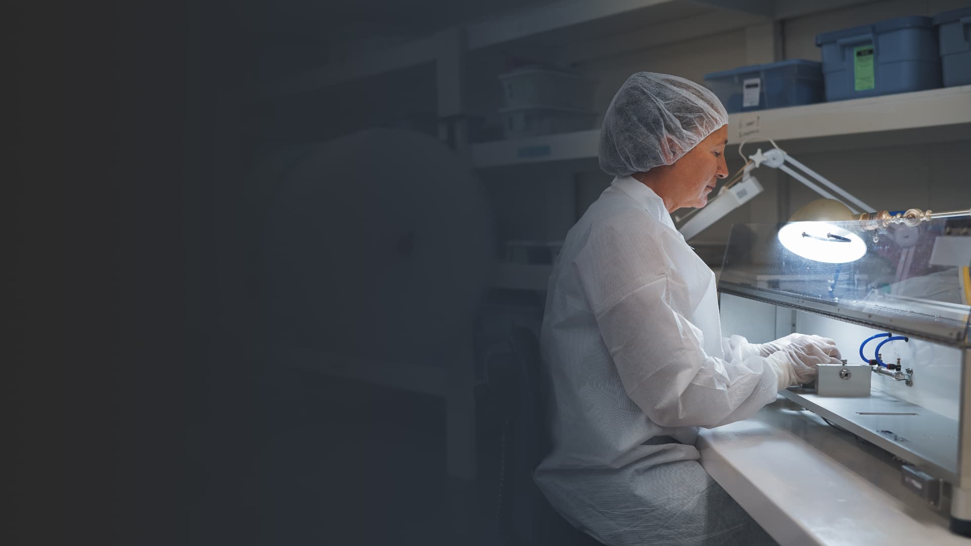 CMI technician assembling components at a cleanroom bench